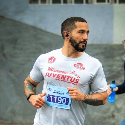 Minha foto correndo, com uma camisa de corrida cinza e o logotipo do clube Juventus na cor grená.